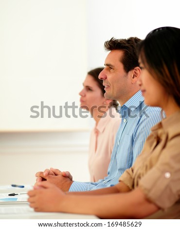 Portrait of male and female coworkers listen during a conference while sitting on office