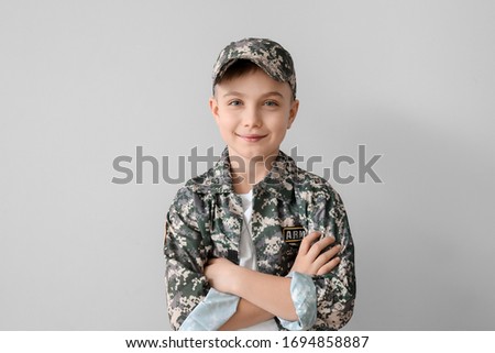 Cute little soldier on light background
