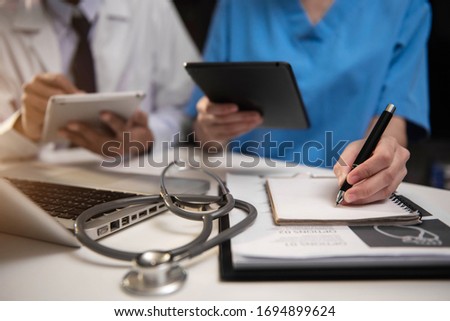 Doctors working together on digital tablet healthcare doctor technology tablet using computer in a modern office.