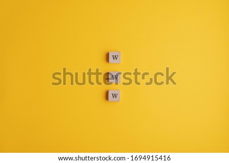 Three wooden blocks reading a www sign placed over yellow background with plenty of copy space.