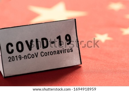 Pandemic sign warning of quarantine due to Covid-19 or corona virus in the China using a chinese flag background,  flag.