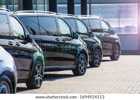 Dark colored passenger vans in a parking lot Royalty-Free Stock Photo #1694924113