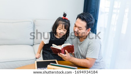 Family praying and worship to GOD with church online sunday service.Live Church with wisdom of GOD in Bible.Father and kid reading on holy bible at home.Quarantine from Covid-19 Coronavirus pandemic Royalty-Free Stock Photo #1694934184