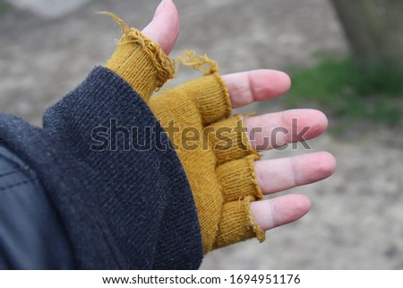 Hand with yellow fingerless gloves