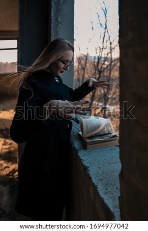 girl sorceress leafing through a book of spells