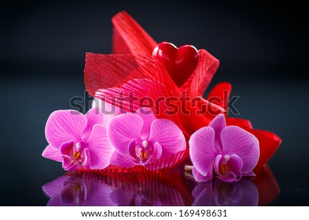 Phalaenopsis branch with a red heart on a black background