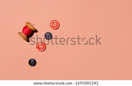 buttons of red color on a brown background. copy space. The concept of sewing and fixing old things. minimalism