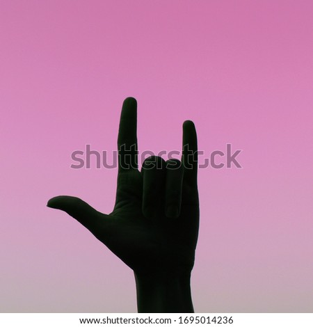 Hand-shaped heart symbol, i love you, with pink light background, silhouette image 