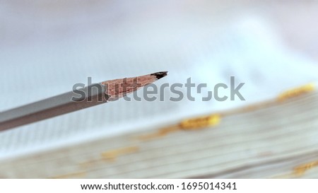 Pencil on open book background, marking while reading