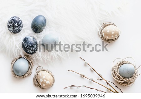 Pastel composition for the holiday of Easter. Colored eggs in natural colors. Background for the presentation of work or text.