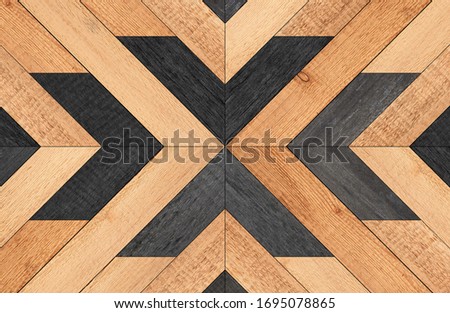 Rustic untreated wooden wall with geometric pattern. Black and brown wooden boards texture.