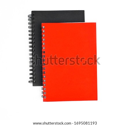 Photo of two paper note diary of red and black color placed on top of each other before a white background