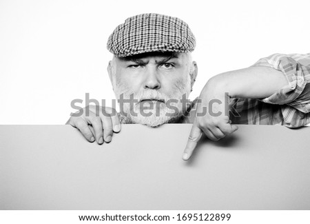 Advertisement shop. Pensioner grandfather in vintage hat hold poster information copy space. Event announcement. Announcement concept. Senior bearded man peek out of banner place announcement.