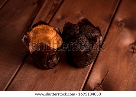 Chocolate and vanilla muffins on a wooden table. Homemade sweets. Tasty snack