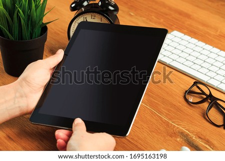 female hands holding tablet on wooden background  , place for your text  - Image 