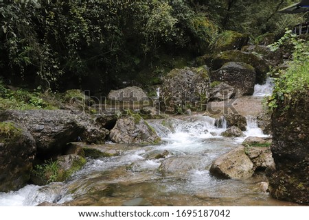 Beautiful landscape of cascade falls over mossy rocks, stones cover with moss, in a Mountain in Sichuan, China