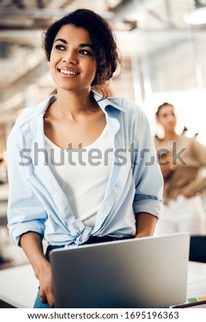 Charming Afro American girl holding modern notebook and smiling stock photo