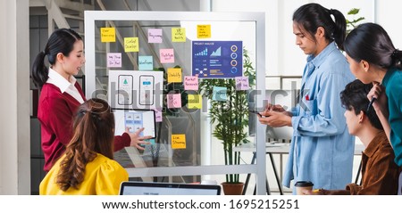 ux developer and ui designer presenting  and testing mobile app interface design on whiteboard in meeting at modern office.Creative digital development mobile app agency