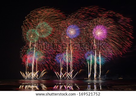 Fireworks of multiples colors with reflections on water