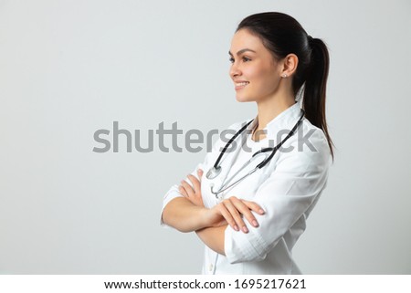 Young pediatrician in white uniform with crossed hands waiting for patient in clinic stock photo. Pediatrics concept