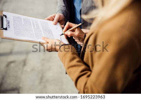 Cropped photo of a female buyer and a realtor concluding a real estate purchase agreement