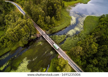 RV from above cruising over bridge over swedish waterscape drone aerial shot