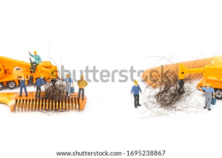 miniature workers with hair on wooden comb, image for solution hair loss concept.