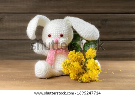 amigurumi bunny with yellow flowers. Easter background