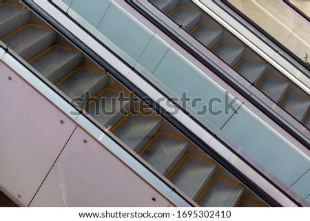 Escalator in metro. Moving up staircase escalator. .Close up to Moving electric escalator.Close up floor platform electric escalator. yellow bands metal line steel. yellow gray steel line.