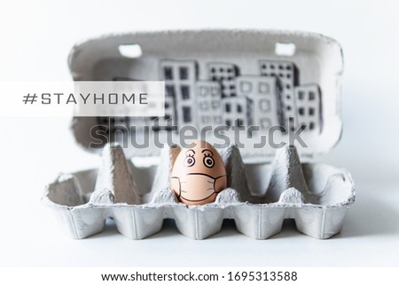 Chicken egg in a tray with doodle face wearing medical mask with city skyline on background. Conceptual image of social distancing and stay at home during Corona virus quarantine
