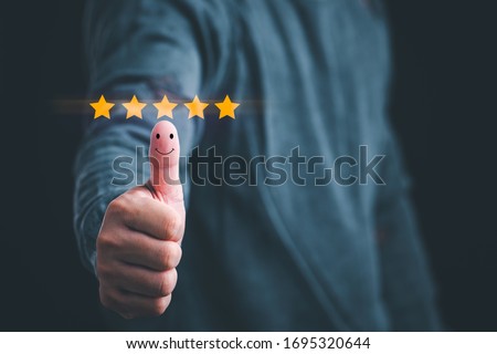 Customer satisfaction concept. Hand with thumb up Positive emotion smiley face icon and five star with copy space. Royalty-Free Stock Photo #1695320644