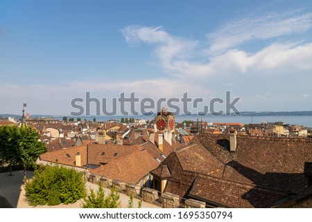 Aerial view of old Neuchatel city with clock tower and lake in background, Switzerland.