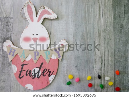 Easter background with copy space. Happy easter bunny  and jelly beans with a wooden background.