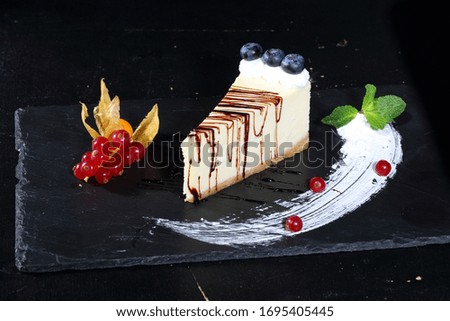 Cheesecake with strawberries, currants and physalis on a white background