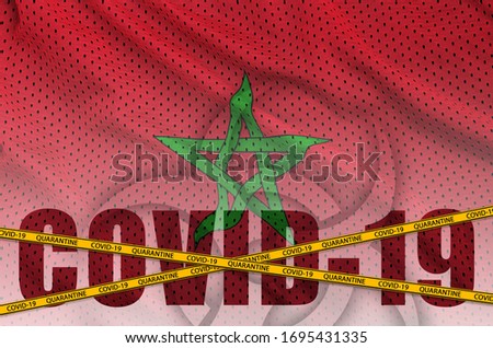 Morocco flag and Covid-19 inscription with orange quarantine border tape. Coronavirus or 2019-nCov virus concept Royalty-Free Stock Photo #1695431335