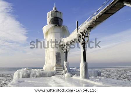 Frozen Passage -- The St. Joseph Pier freezes over during the early winter season. The pier is a solid sheet of ice. Saint Joseph, Michigan, USA. Royalty-Free Stock Photo #169548116