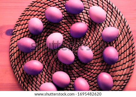 Top view pink purple eggs on the table round wicker Board in the kitchen