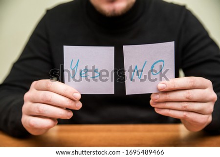 Man holds two piece of paper. Close up