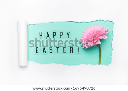 Creative layout made of torn hole, Happy Easter text and pink gerbera flower. Happy easter concept.