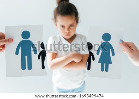 selective focus of man and woman holding ripped paper with separated family near displeased african american daughter isolated on white