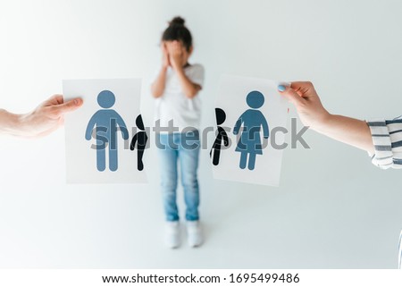 selective focus of man and woman holding ripped paper with separated family near adopted african american daughter on white