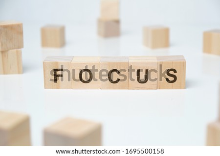Modern business buzzword - focus. Word on wooden blocks on a white background. Close up.