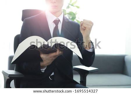 Lawyer holding fist with law book.Chinese character 'beobjeon' means code of laws,law book.