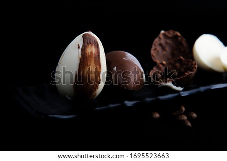 Chocolate eggs, handmade.Selective focus.Black background.Horizontal.Space for your text.