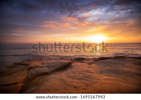 The sky erupts in vibrant colors, as the sun sets over the Pacific Ocean, at Sunset Cliffs in San Diego, California. Royalty-Free Stock Photo #1695567943