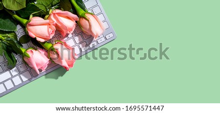 Computer keyboard with pink roses - flat lay