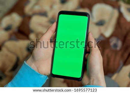 using smart phone with green screen. hands scrolling pages, tapping on touch screen. top view. Chroma key