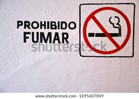 Symbol and wording that say (no fumar)--no smoking in Spanish on white wall with copy space