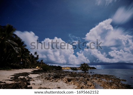 Beautiful seascape with cloudy sky with stars. Night on the tropical beach.