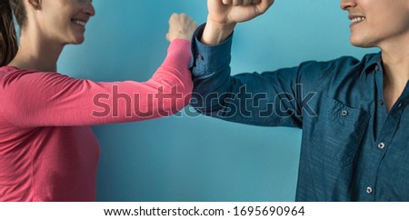 Elbow bump greeting to avoid the spread of coronavirus. Two people friends greet by bumping elbows instead of greeting with a hug or handshake. Don't shake hands.  Royalty-Free Stock Photo #1695690964